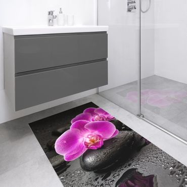 Dywan winylowy - Kwiaty różowej orchidei na kamieniach z kroplami