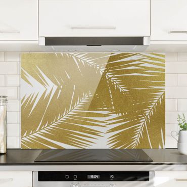 Panel szklany do kuchni - Widok przez złote liście palmy