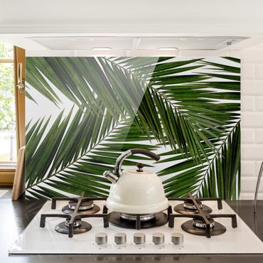 Panel szklany do kuchni - Widok przez zielone liście palmy