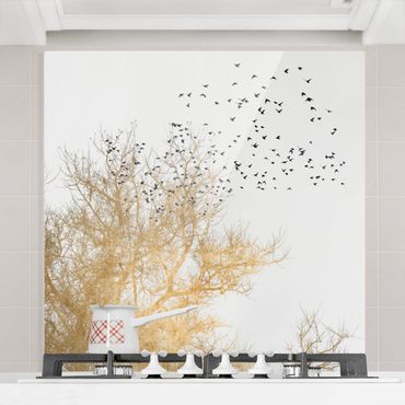 Panel szklany do kuchni - Stado ptaków na tle złotego drzewa