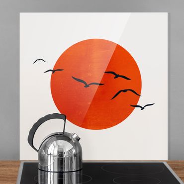 Panel szklany do kuchni - Stado ptaków na tle czerwonego słońca I
