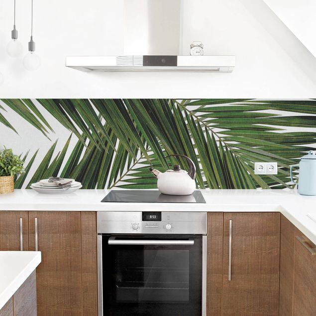 Panele szklane do kuchni Widok przez zielone liście palmy