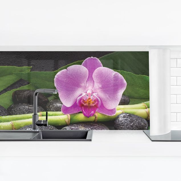 Panele szklane do kuchni Zielony bambus z kwiatem orchidei