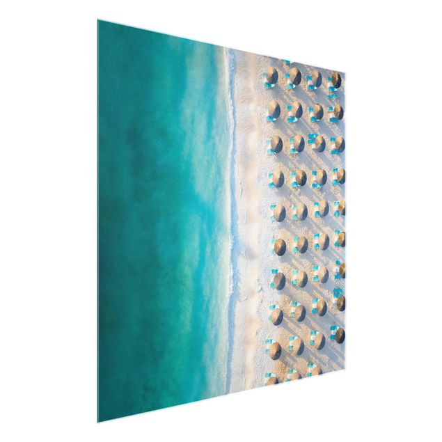 Obrazy na szkle krajobraz Biała piaszczysta plaża z parasolami słomkowymi