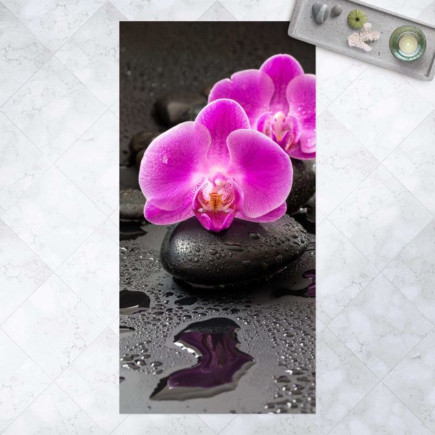 dywan ogrodowy Kwiaty różowej orchidei na kamieniach z kroplami