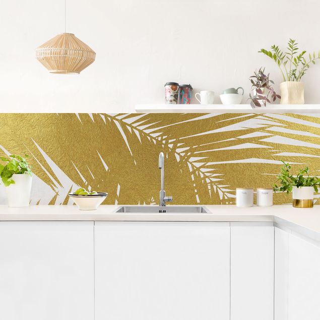 Panele szklane do kuchni Widok przez złote liście palmy
